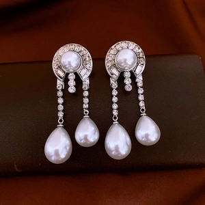 Dettaglio di orecchini geometrici di lusso con strass e perle a forma di goccia