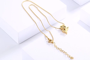 Golden rose pendant necklace with a sleek snake chain shown on a minimalist white stand