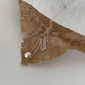 Detailed view of 925 sterling silver ball pendant necklace on honeycomb packaging paper