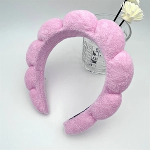 Close-up of pink cloud sponge headband with soft towel texture for skincare use