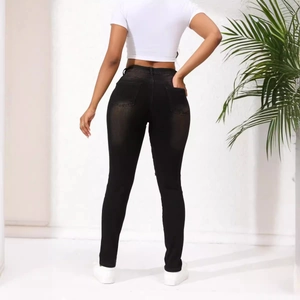 Jean skinny noir moulant avec détails déchirés et effet galbant vue de dos