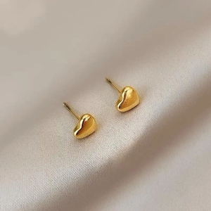 Polished 18K gold heart-shaped titanium steel studs on champagne silk fabric background