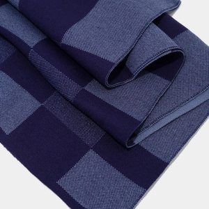 Close-up of blue checkerboard knit scarf showing detailed texture and soft fiber finish