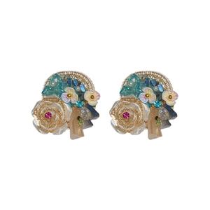 Elegant baroque flower earrings with silver needles and crystals on a white backdrop