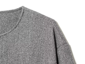 Macro detail of grey wool bomber jacket showing ribbed crew neck and textured fabric