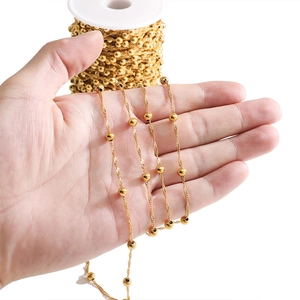 Close-up of golden beaded water wave chain for DIY necklace jewelry making held in hand