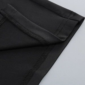Detailed macro view of black off-shoulder dress featuring premium stitching and knit fabric