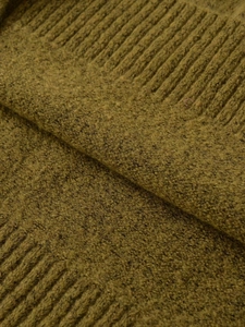 Detail of olive green melange knit fabric with soft texture and ribbed cuffs