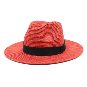 Detailed view of red straw fedora with black ribbon band and wide flat brim