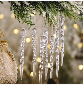 Macro shot of spiral clear acrylic icicle ornaments on a snowy Christmas tree branch