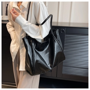 Grand sac cabas noir en cuir huilé brillant, design minimaliste porté épaule pour femme