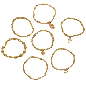 Detailed view of 7-piece gold bracelet set featuring cross, heart and star charms