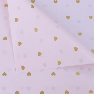 Detail of pink tissue paper with gold heart foil print for floral gift wrapping