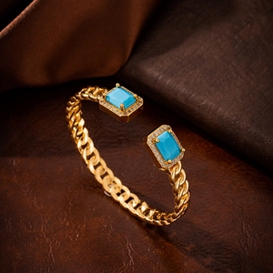 Detailed view of golden cubic chain bracelet featuring blue stones and zircon accents