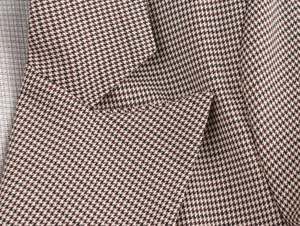 Dettaglio ravvicinato di blazer pied-de-poule con trama del bavero e patta della tasca
