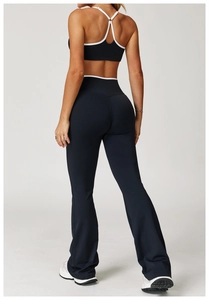 Achteraanzicht van zwarte flare-legging en sportbeha met witte contrasterende biesjes