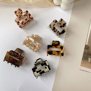 Flat lay of small acetate claw clips in tortoiseshell and checkerboard patterns