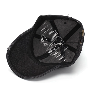 Detail of washed black denim baseball cap showing metal buckle and inner structure