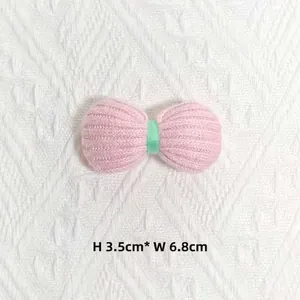 Détail d'un nœud tricoté rose et vert menthe, dimensions 3,5 cm de haut sur 6,8 cm de large