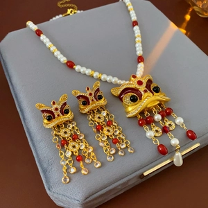 Dettaglio del set gioielli vintage danza del leone con perle, nappe e monete d'oro