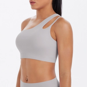 Detail of light gray one-shoulder yoga bra featuring stylish cutout strap design