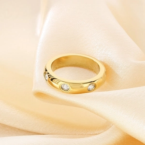 Detailed view of wide 18K gold plated stainless steel ring with three round cubic zirconia