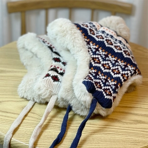 Detail of warm winter knit trapper hat with thick faux fur lining and jacquard pattern