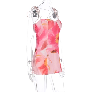 Détail de la mini-robe rose à fleurs avec découpe à la poitrine et fines bretelles