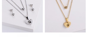 Détail de colliers doubles en acier inoxydable avec pendentifs patte de cœur et boucles
