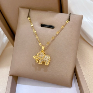 Detailed view of a gold elephant pendant necklace with zircon micro-pave on a display board
