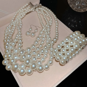 Detailed set of multi-layer pearl necklace, bracelet and earrings in a pink gift box