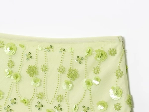 Detail shot of light green mesh fabric with exquisite floral sequins and beadwork