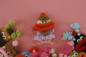 Detail of colorful hand-knitted monster key covers with soft wool textures and metal rings