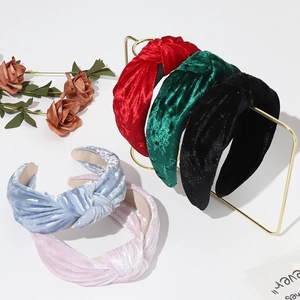 Various velvet knotted headbands in red, green, black and pink on a gold stand