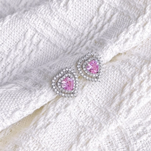 Macro detail of heart-shaped pink gemstone earrings with double halo zircon stones
