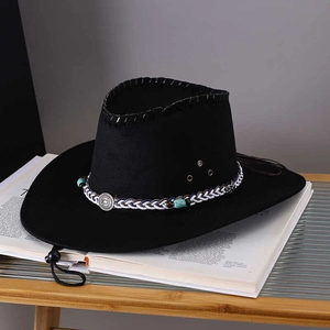 Black western cowboy hat with ethnic woven band and turquoise beads on an open book