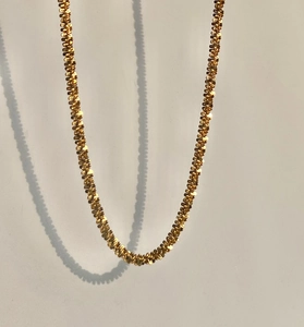 Macro detail of 18k gold plated stainless steel textured link chain with glossy finish