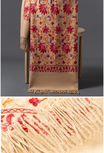 Vue macro de la broderie florale et des franges faites main sur une écharpe en cachemire