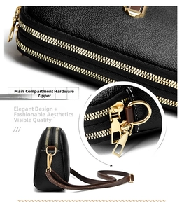 Close-up of black litchi pattern leather shell bag with dual gold zippers and metal hardware