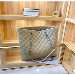 Dettaglio della borsa tote trapuntata beige con catena argento e trama a rombi