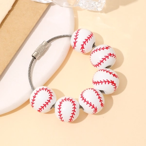 Detail of baseball charm keychain with white stitched beads and textured metal clasp