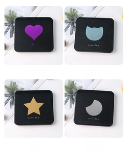 Detail of four compact mirrors featuring heart, cat, star, and moon foil patterns