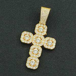 Close-up of a gold hip-hop cross pendant with micro-pave crystals and large center stones
