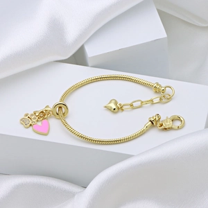 Gold snake chain bracelet featuring sparkling cat paw charm and pink enamel heart pendant