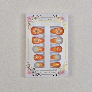 Faux ongles amande français avec dégradé orange et motifs floraux en relief 3D