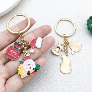 Detail of Christmas keychains with Santa Claus and Merry Christmas enamel pendants