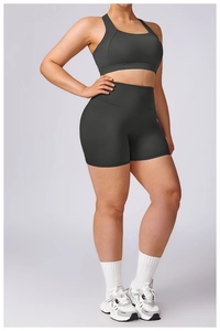 Detail view of high-waist charcoal gray sports bra and shorts on a plus size model