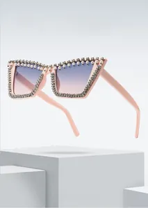 Detail of oversized pink sunglasses with rhinestone frames and pearl top embellishments