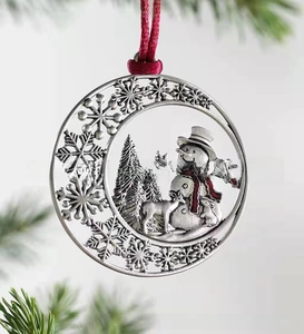 Detail showing vintage silver snowman and reindeer ornament on evergreen branch
