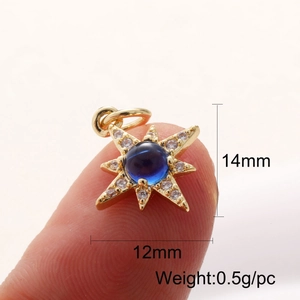 Macro shot of 14K gold-plated star pendant with blue gemstone and clear crystals
